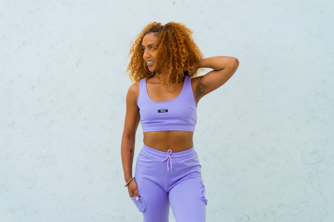 A Woman wearing a crop top and sweat pants.